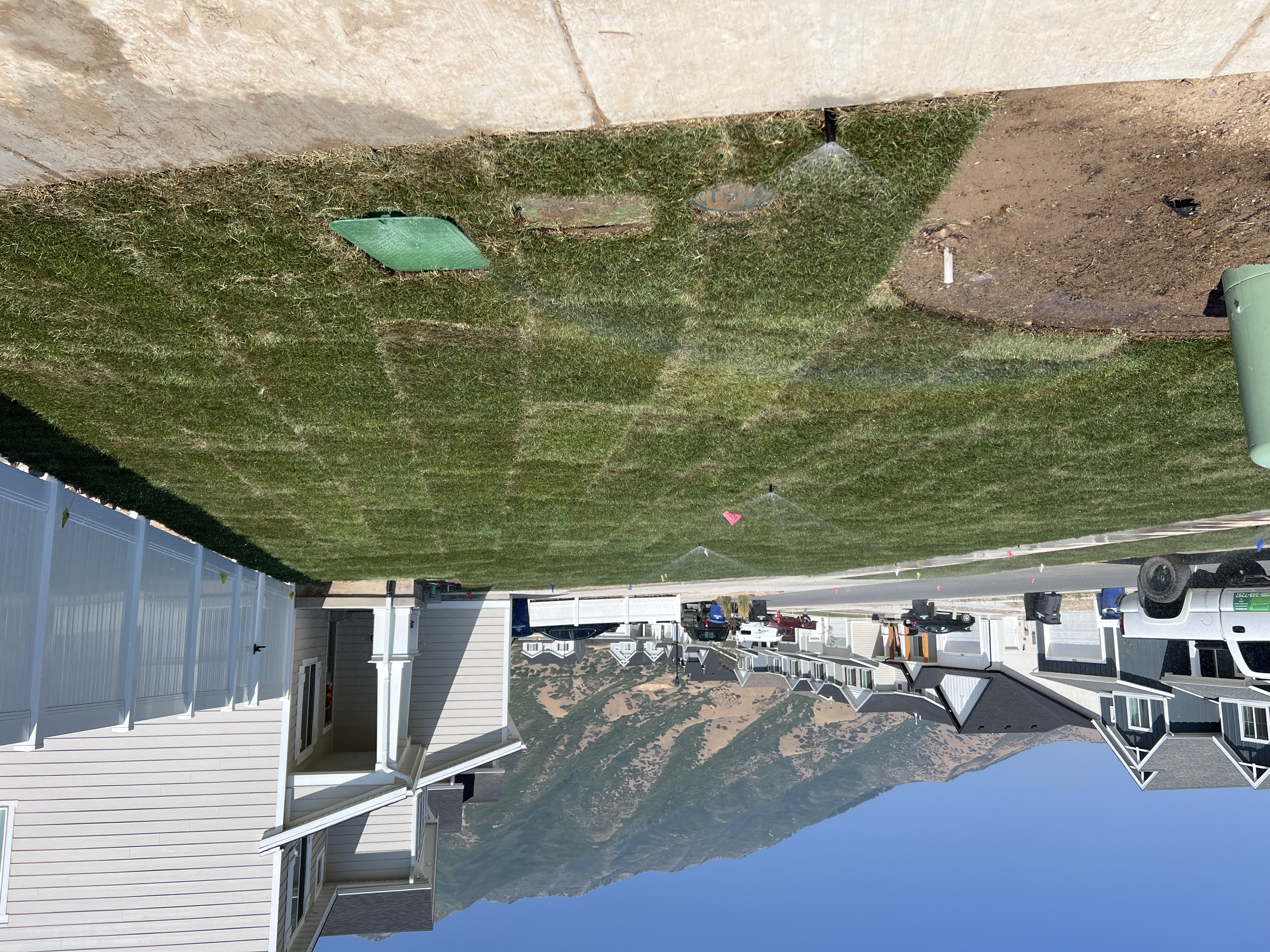 New build corner lot side yard after sod and sprinkler installation in Utah