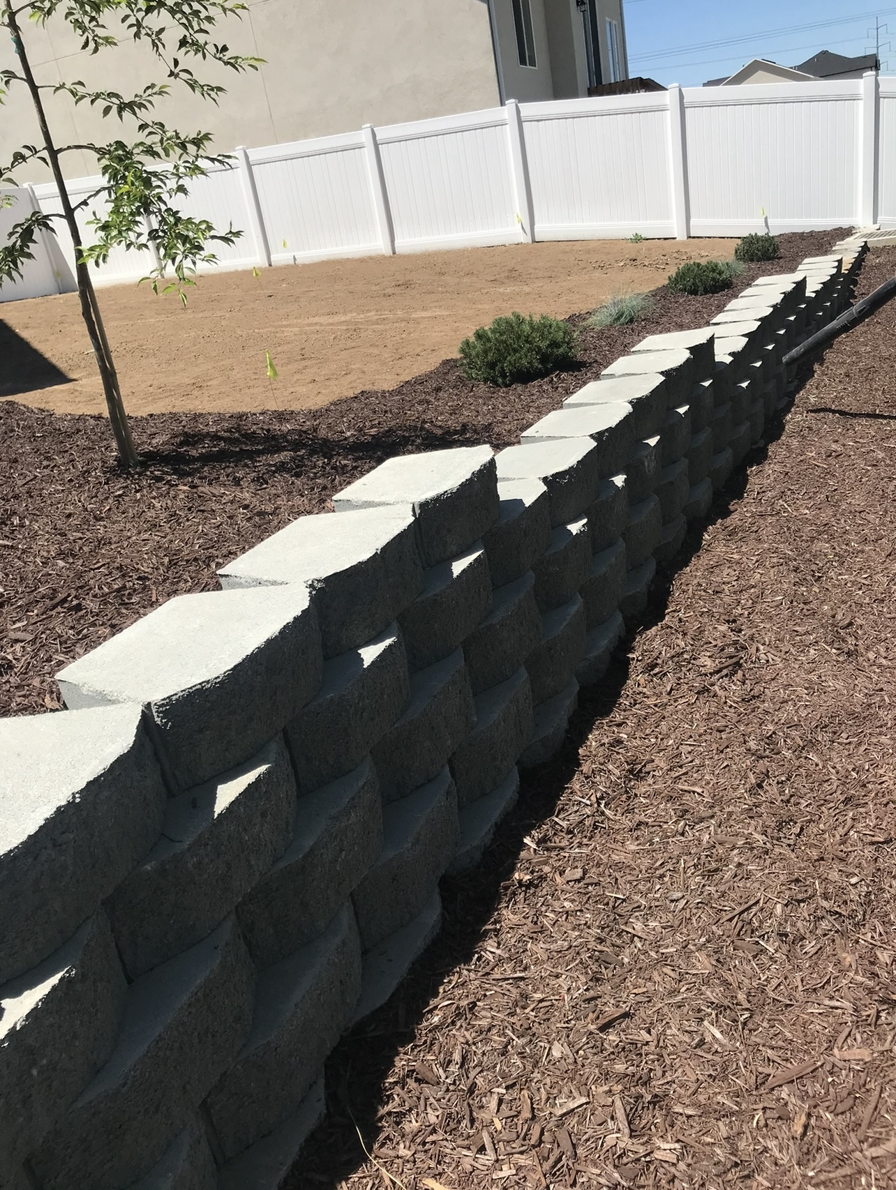 Retaining wall landscaping after mulch and finished yard work in Utah